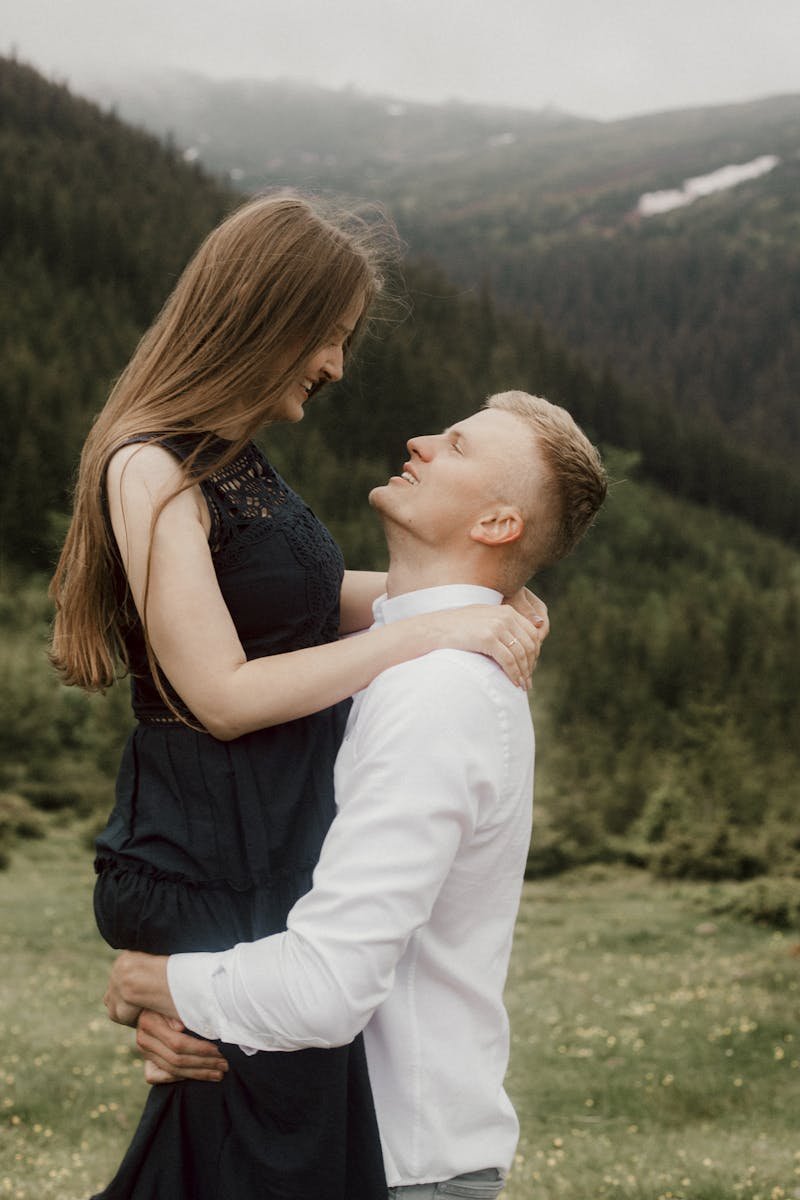 Photo by Pavel Danilyuk A loving couple enjoys a tender moment in a scenic outdoor setting, surrounded by lush greenery.