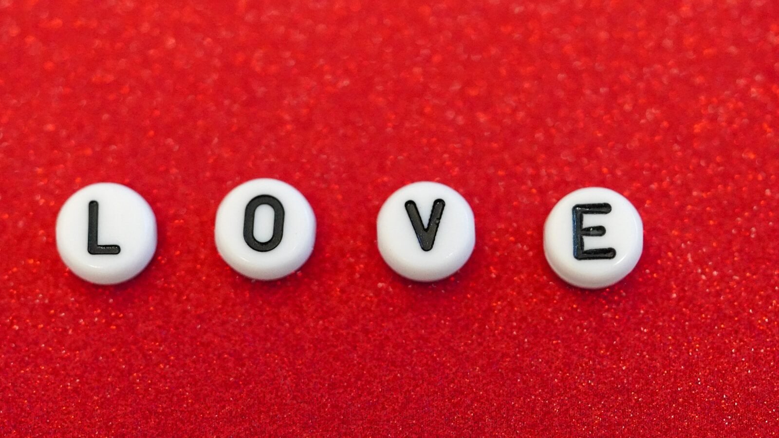 the word love spelled out in small letters on a red surface